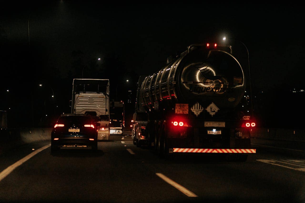 heros-img Vehicles drive down a dark highway at night, showcasing traffic and car lights.